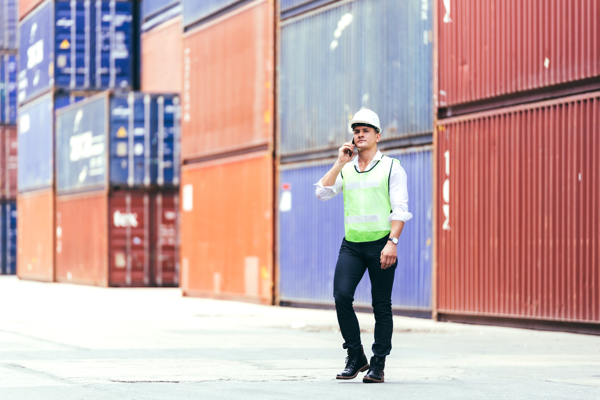 Engineer foreman talking on phone in the container warehouse