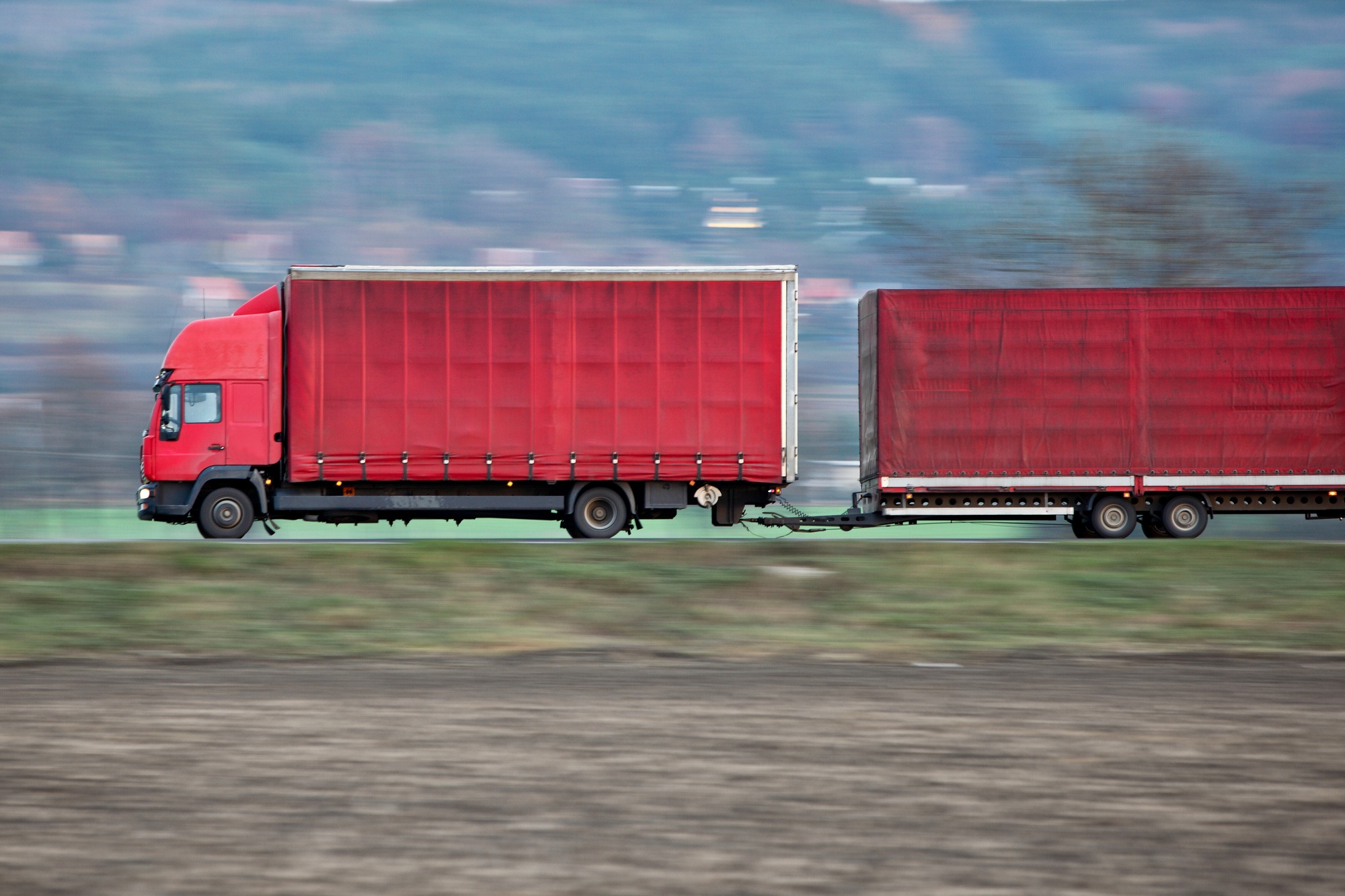 red camion/truck goes fast on a road (panned image - motion blur